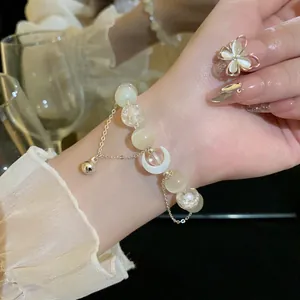 Primo piano dettagliato di un bracciale in perle occhio di gatto con luna e oro