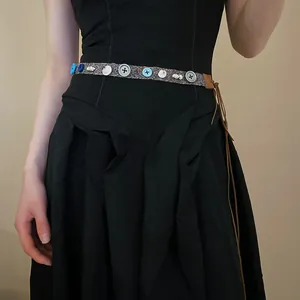 Detailed view of bohemian ethnic waist belt with colorful buttons, shells and leather strap