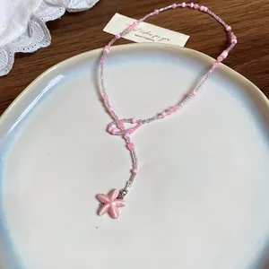 Detailansicht einer süßen rosa Perlenkette mit einem zarten Seestern-Anhänger für Damen.