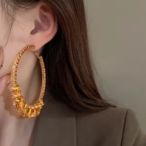 Macro detail of luxury vintage oversized hoop earrings with faceted amber crystals on model