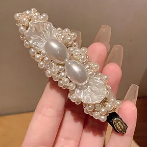 Detailed view of an elegant pearl petal duckbill clip featuring a handmade gold tag