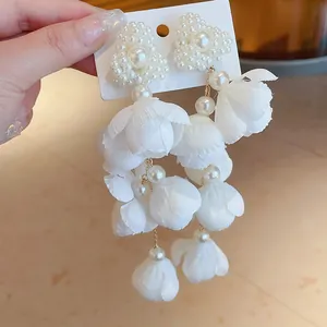 White fabric flower petal drop earrings with pearl heart detail in forest style