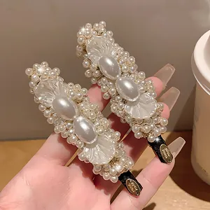 Elegant vintage pearl and petal duckbill hair clips shown in close-up detail display