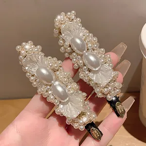 Close-up of elegant pearl and petal hair clips with handmade gold tag