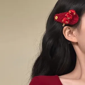 Close-up of a red flocked tanghulu hair clip worn by a model with dark wavy hair.