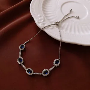 Elegante bracciale regolabile color argento con pietre in resina blu e cristalli brillanti.
