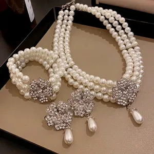 Elegantes mehrlagiges Perlen-Schmuckset mit funkelnden Blumenanhängern und Tropfen.