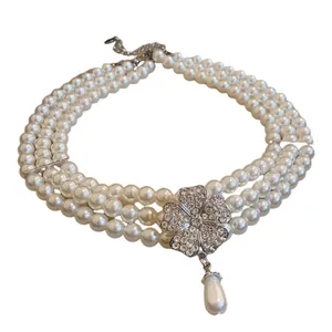 Elegante dreilagige Perlenkette mit Kristallblumen-Anhänger und hängender Perle für Damen.