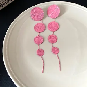 Elegant vintage pink tiered textured circular dangle earrings displayed on a white plate