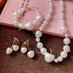 Elegant cherry-shaped pearl jewelry set including necklace, bracelet, and drop earrings