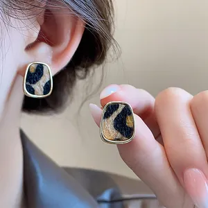 Detalle de la textura de pendientes vintage de leopardo con elegante borde dorado