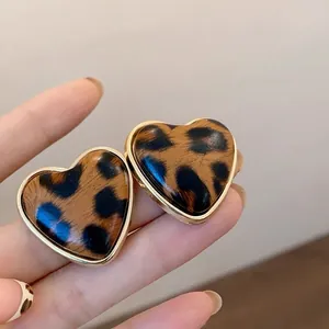 Primer plano de pendientes de corazón con estampado de leopardo y bordes dorados