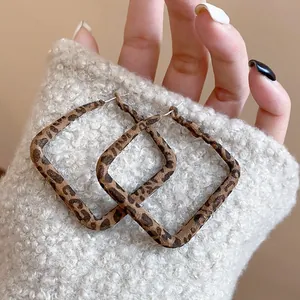 Primer plano de pendientes de aro cuadrados con estampado de leopardo.