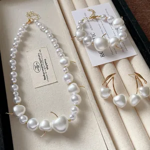 Elegant French style pearl jewelry set featuring necklace, bracelet, and cherry earrings.