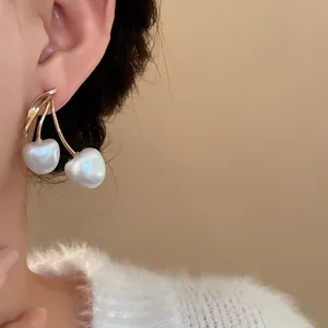 Detailed view of elegant cherry-shaped earrings with white pearls and gold-tone stems.