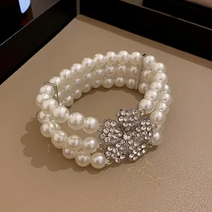 Nahaufnahme einer mehrlagigen Perlenkette im französischen Stil mit einer Glitzerblume