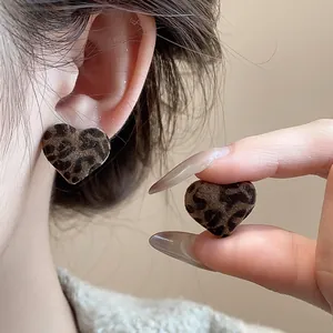 Primer plano de pendientes de corazón con estampado de leopardo y textura aterciopelada