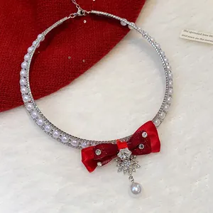 Detail view of red velvet bow and snowflake pendant with shimmering rhinestones and pearl