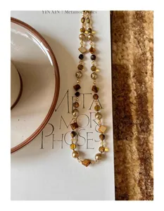 Detailed close-up of Maillard style irregular tiger eye stone and pearl beaded necklace