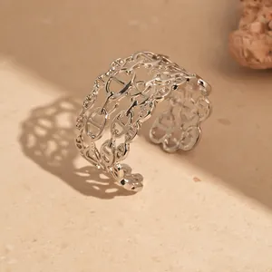 Primo piano dettagliato di un bracciale rigido aperto argento con motivo a maglie