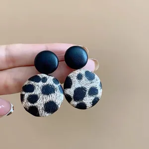 Primer plano de la textura de los pendientes vintage de leopardo y cuero negro