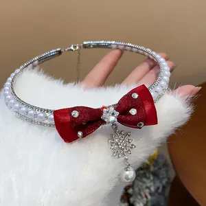 Close-up of elegant red bow pearl choker with a sparkling rhinestone snowflake pendant.