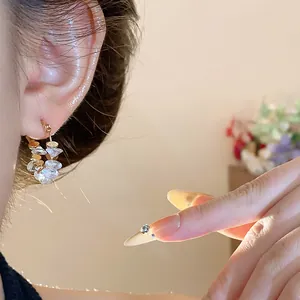 Primo piano elegante di orecchini a cerchio placcati oro 18k con cristalli trasparenti sul modello