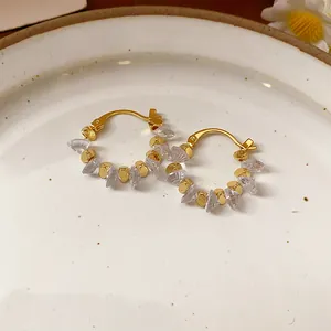 Dettaglio degli orecchini a cerchio placcati oro 18 carati con perline di cristallo