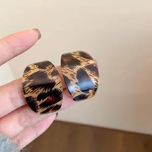 Vista detallada de pendientes vintage con estampado de leopardo y acabado brillante