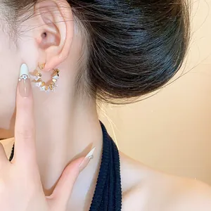 Primo piano di eleganti orecchini a cerchio placcati oro 18k con cristalli scintillanti