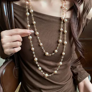 Dettaglio di elegante collana a due strati con perle color champagne e perle di cristallo