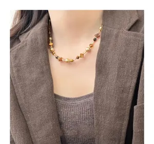 Model wearing irregular tiger eye and pearl beaded necklace with Maillard style brown outfit