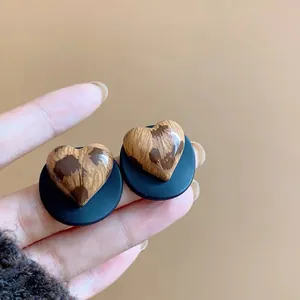 Primer plano de pendientes de corazón vintage con estampado de leopardo y base negra