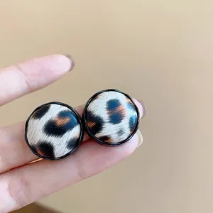 Primer plano de pendientes circulares con estampado de leopardo y borde negro