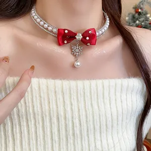 Close-up detail of festive red ribbon bow choker with snowflake pendant and pearls