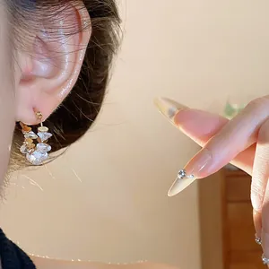 Inquadratura dettagliata di orecchini a cerchio placcati oro 18k con cristalli chiari