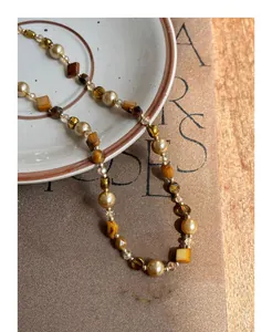 Close-up detail of a vintage beaded necklace with tiger eye stones and elegant pearls