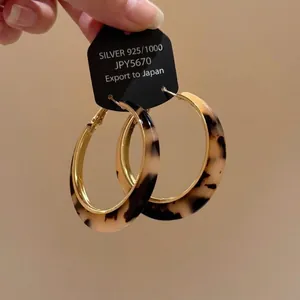 Detailed view of vintage tortoiseshell leopard print hoop earrings with gold trim