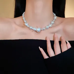 Elegant French style pearl necklace with gold thorn accents worn by model on neck