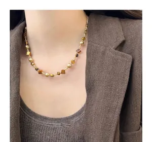Close-up of Maillard style beaded necklace with irregular tiger eye stones and pearls