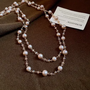 Dettaglio elegante di una collana a due strati con perle color champagne e cristalli