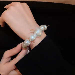 Close-up of unique cherry-shaped pearl necklace worn as a stylish bracelet on a wrist