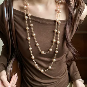 Dettaglio ravvicinato di un'elegante collana di perle a due strati su un abito.