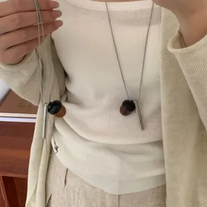 Vue détaillée d'un collier avec pendentif en forme de gland sur un mannequin.