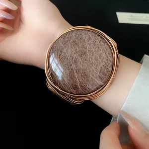 Vista detallada de un gran brazalete redondo de resina con texturas tejidas de hilo de cobre