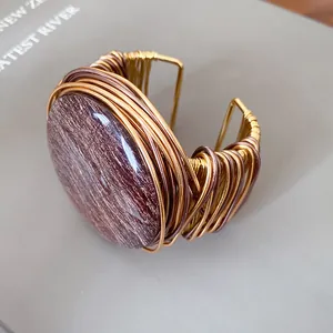 Primer plano detallado de un brazalete de resina vintage con tejido de alambre dorado