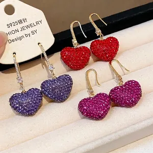 Elegant heart-shaped earrings featuring sparkling colorful rhinestones on gold hooks
