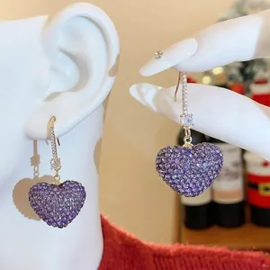 Elegant gold hook earrings featuring sparkling purple zircon micro-pave hearts