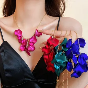 Vue détaillée de colliers à glands pétales en satin colorés avec chaînes dorées sur modèle