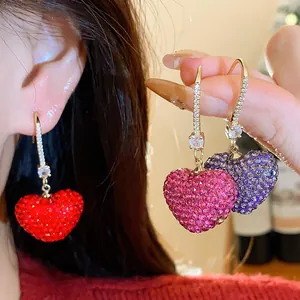 Close-up of sparkling heart-shaped earrings with colorful rhinestone pave detail setting